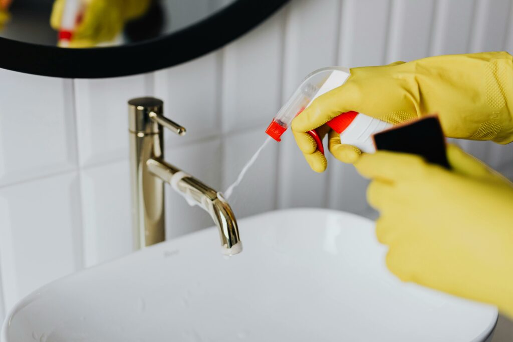 Nettoyage d'un lavabo par une personne avec un produit spécifique